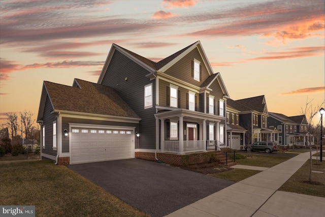 view of front of house with covered porch, asphalt driveway, an attached garage, and a residential view