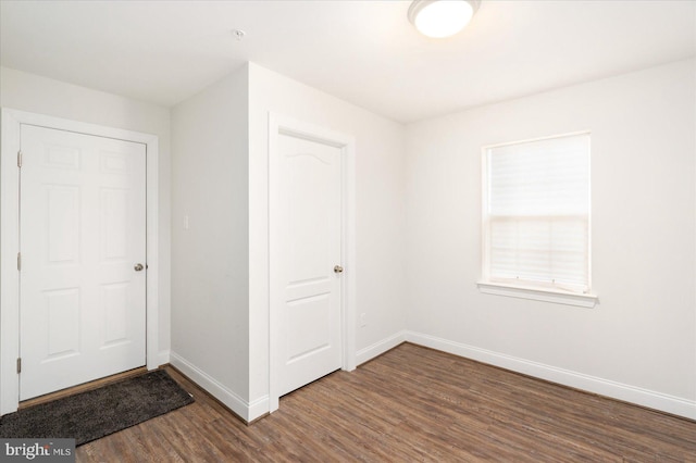 unfurnished bedroom featuring baseboards and wood finished floors
