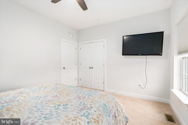 unfurnished bedroom with carpet flooring, baseboards, a closet, and ceiling fan