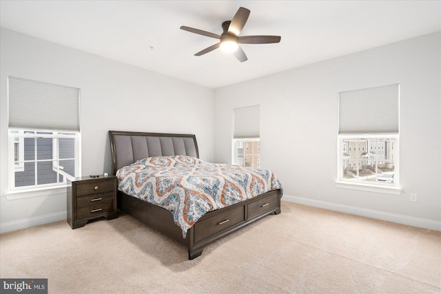 bedroom featuring light carpet, baseboards, and a ceiling fan