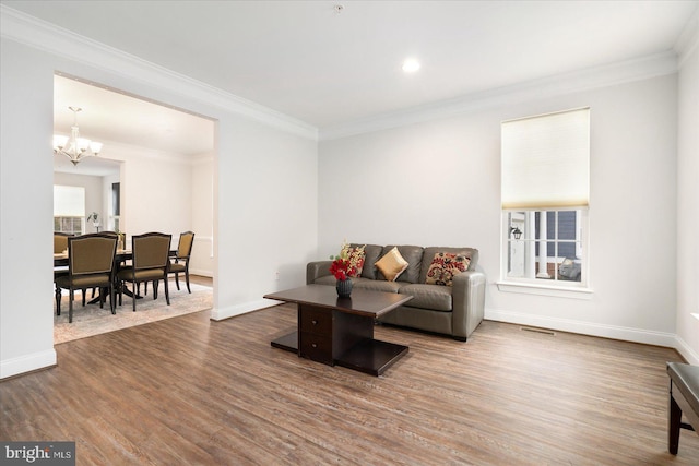 living room featuring a chandelier, wood finished floors, baseboards, crown molding, and recessed lighting