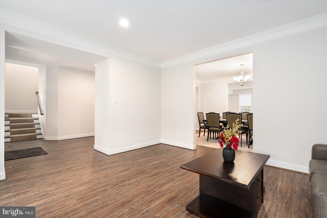 living room with dark wood-style flooring, a chandelier, crown molding, baseboards, and recessed lighting