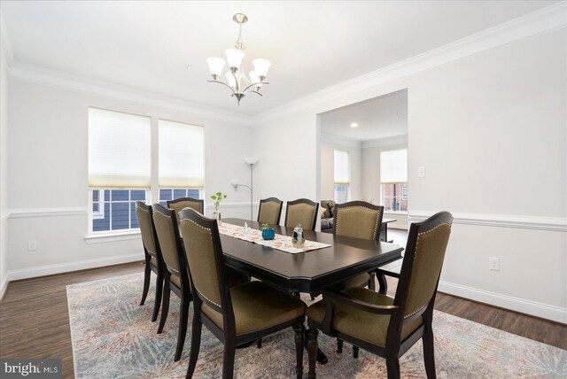dining room featuring a chandelier, wood finished floors, baseboards, and ornamental molding