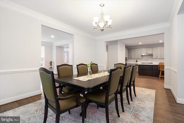 dining room with a chandelier, wood finished floors, baseboards, ornamental molding, and recessed lighting
