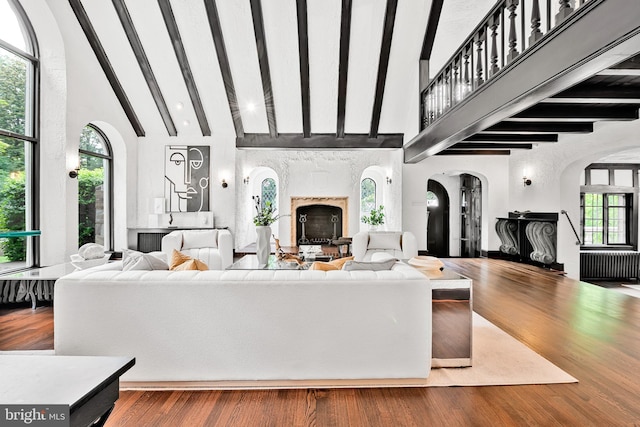 302 Ellsworth Dr, Silver Spring, MD 20910 - living room with arched walkways, beamed ceiling, high vaulted ceiling, a high end fireplace, and wood finished floors