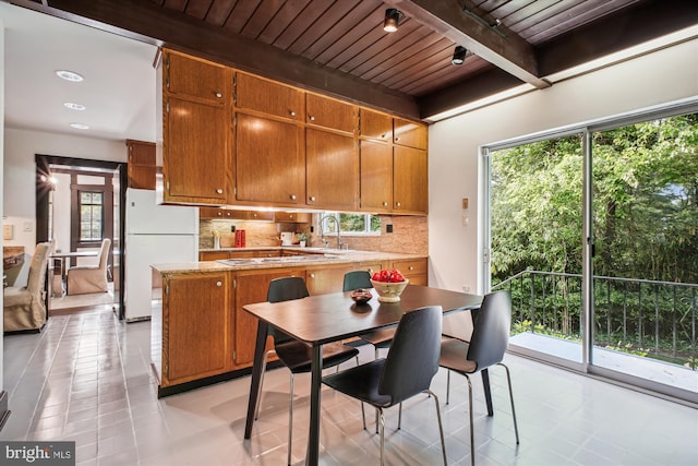 302 Ellsworth Dr, Silver Spring, MD 20910 - kitchen with freestanding refrigerator, wood ceiling with exposed beams, backsplash, light tile patterned flooring, and brown cabinets