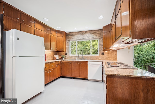 302 Ellsworth Dr, Silver Spring, MD 20910 - kitchen with white appliances, tasteful backsplash, brown cabinets, light stone countertops, and a sink