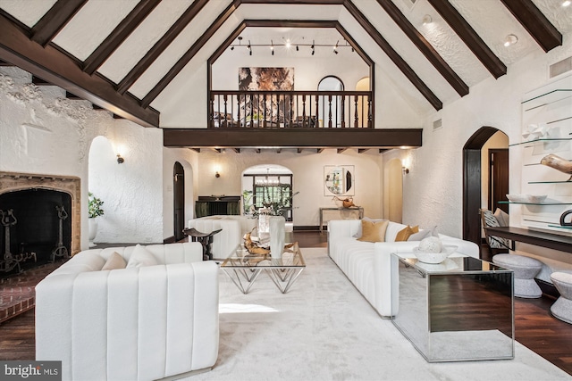 302 Ellsworth Dr, Silver Spring, MD 20910 - living area with arched walkways, high vaulted ceiling, wood finished floors, beam ceiling, and a brick fireplace