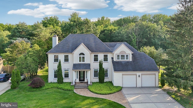 15 Horseshoe Dr, Mount Laurel, NJ 08054 - view of front of house with a chimney, concrete driveway, a front lawn, stucco siding, and roof with shingles