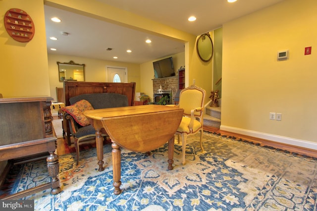 dining area with recessed lighting, wood finished floors, a fireplace, baseboards, and stairs