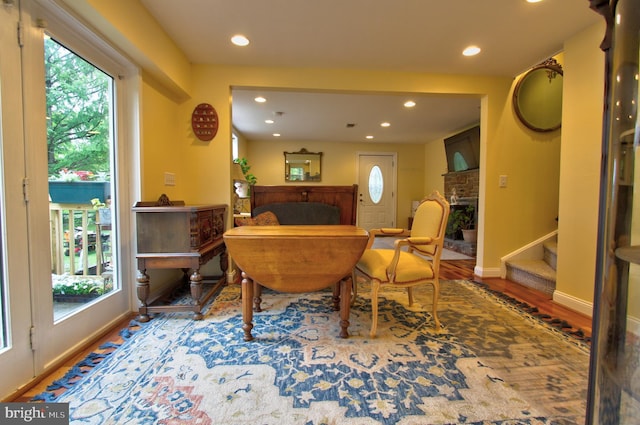 living area featuring recessed lighting, a fireplace, wood finished floors, stairway, and baseboards