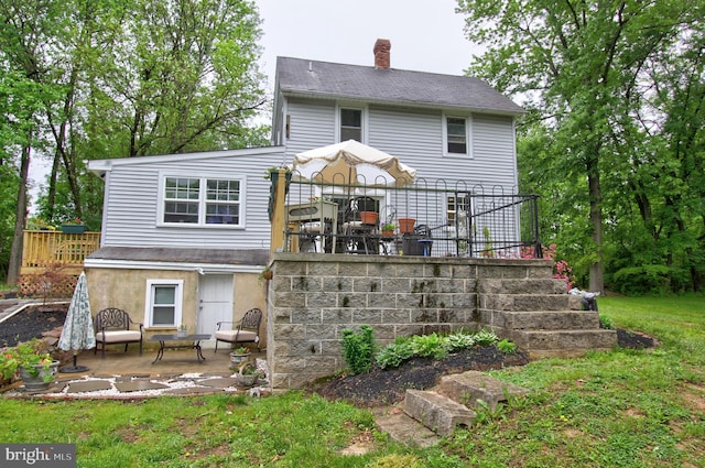 back of house with a chimney, a patio, and stairs