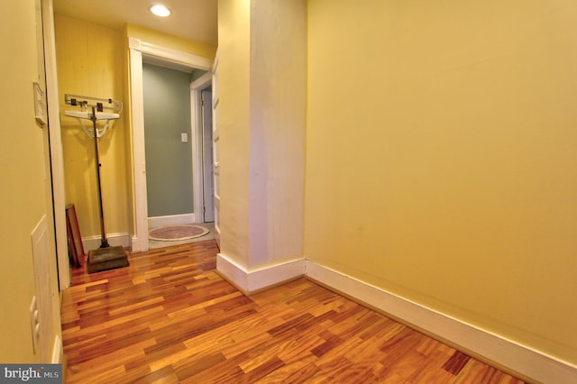corridor with light wood-style floors, recessed lighting, and baseboards