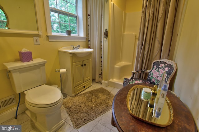 bathroom featuring healthy amount of natural light, a stall shower, tile patterned floors, and toilet
