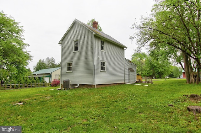 rear view of house with a chimney and central air condition unit