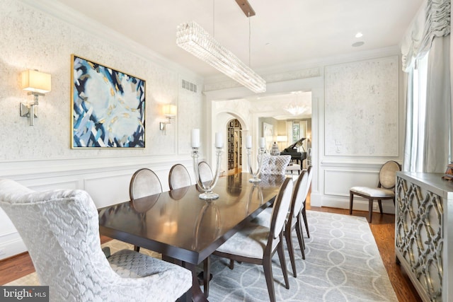 51 Farrier Ln, Newtown Square, PA 19073 - dining area with ornamental molding, wood finished floors, a decorative wall, wainscoting, and arched walkways