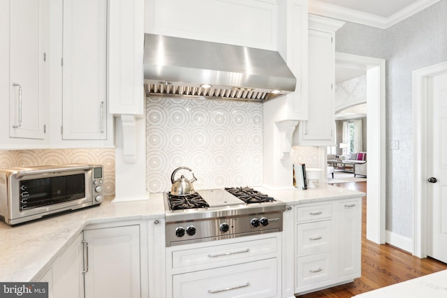 51 Farrier Ln, Newtown Square, PA 19073 - kitchen featuring wall chimney exhaust hood, stainless steel gas stovetop, white cabinetry, ornamental molding, and wood finished floors