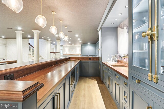 51 Farrier Ln, Newtown Square, PA 19073 - bar area featuring light wood-style flooring, ornate columns, a textured ceiling, pendant lighting, and recessed lighting