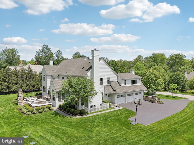 51 Farrier Ln, Newtown Square, PA 19073 - back of property with an attached garage, a chimney, driveway, and a yard