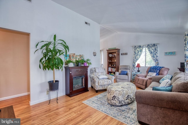 388 Monument Dr, Montross, VA 22520 - living room with wood finished floors, vaulted ceiling, baseboards, and a glass covered fireplace