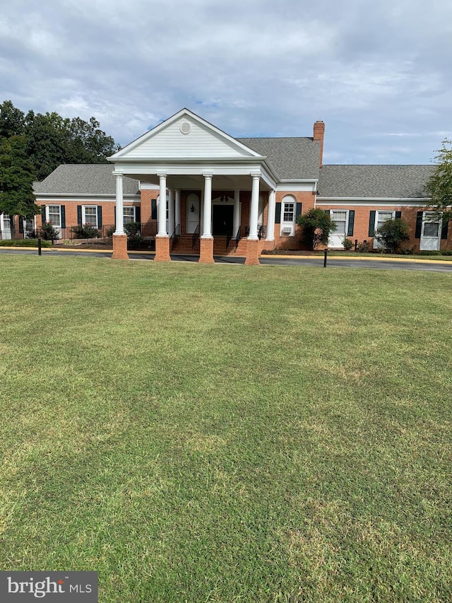388 Monument Dr, Montross, VA 22520 - neoclassical / greek revival house featuring covered porch, a front lawn, brick siding, and a chimney