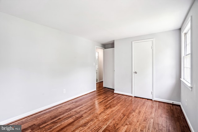 12303 Captain Smith Ct, Rockville, MD 20854 - unfurnished bedroom with wood finished floors, multiple windows, and baseboards