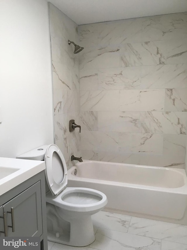 bathroom with marble look tile flooring, vanity, bathtub / shower combination, and toilet