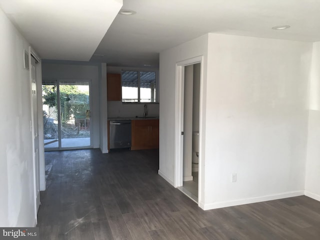 corridor featuring a sink, dark wood finished floors, baseboards, and recessed lighting