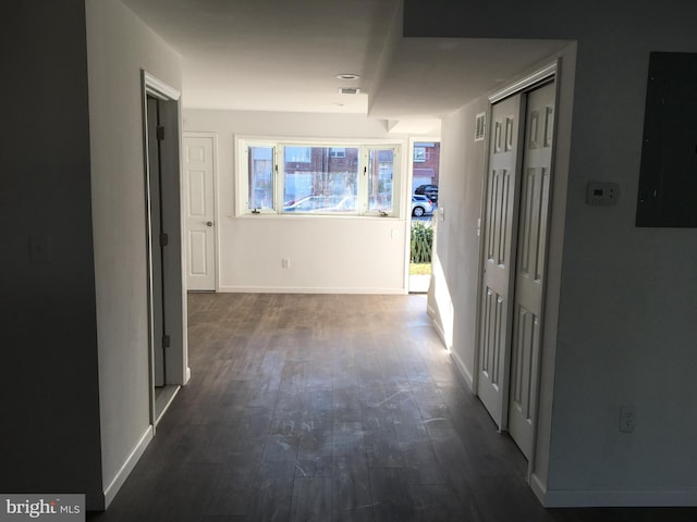 hallway featuring electric panel, dark wood finished floors, and baseboards
