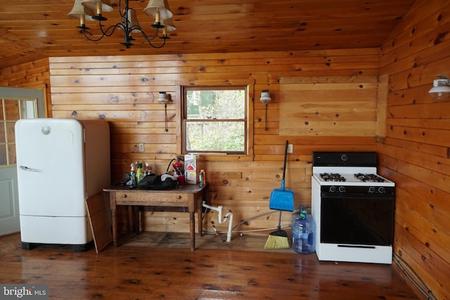 kitchen with white range with gas stovetop, lofted ceiling, hardwood / wood-style flooring, wood walls, and a chandelier