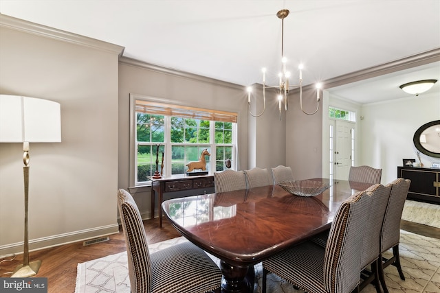 dining area with ornamental molding, plenty of natural light, wood finished floors, a chandelier, and baseboards