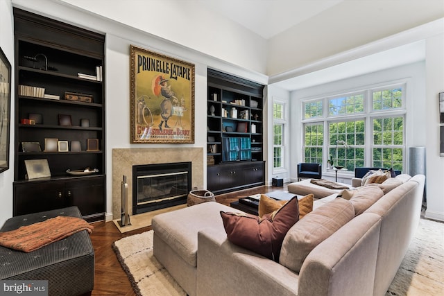 living room with built in features and a premium fireplace