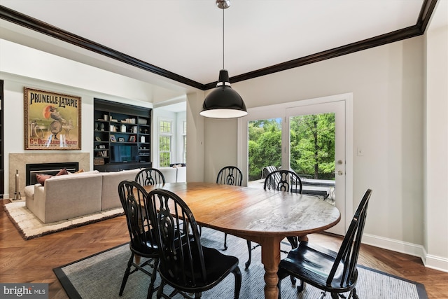 dining area with crown molding, baseboards, and a fireplace