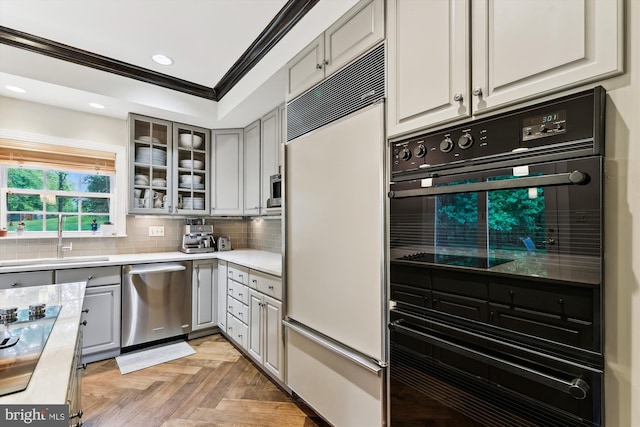kitchen featuring dishwasher, built in refrigerator, a sink, light countertops, and ornamental molding