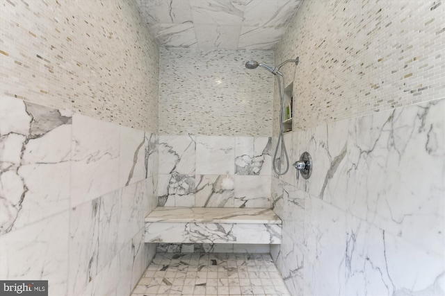 bathroom featuring a marble finish shower