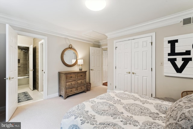 carpeted bedroom with crown molding, a closet, baseboards, and ensuite bathroom