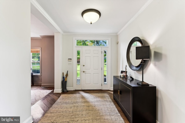 entrance foyer with dark wood-style flooring, ornamental molding, and baseboards