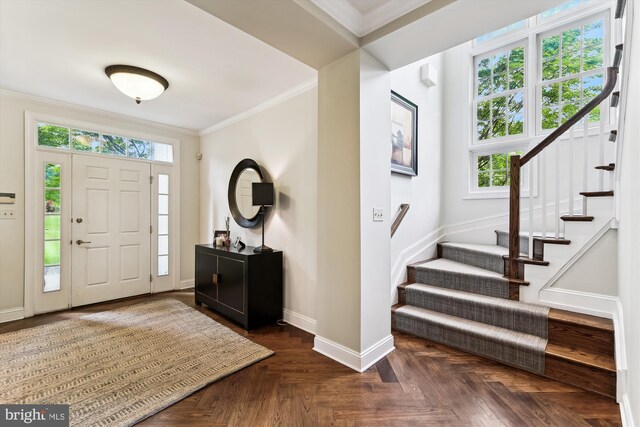 foyer entrance featuring plenty of natural light, stairway, baseboards, and ornamental molding