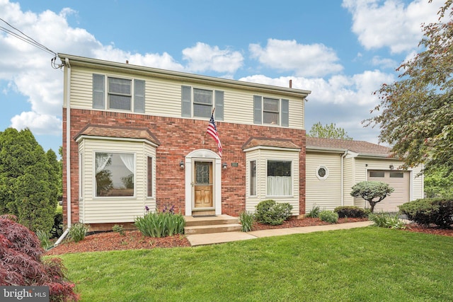 view of front of house with a front yard, a garage, and brick siding