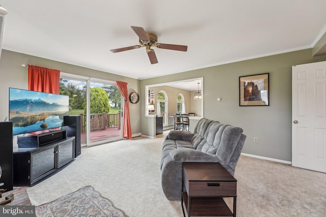 carpeted living area featuring a ceiling fan, ornamental molding, and baseboards