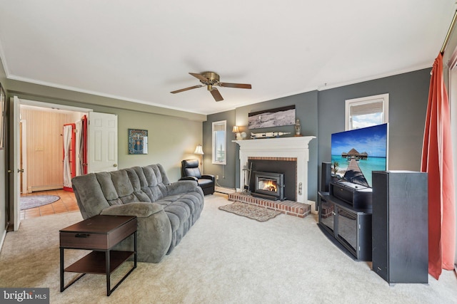 carpeted living area with ornamental molding, ceiling fan, and a brick fireplace