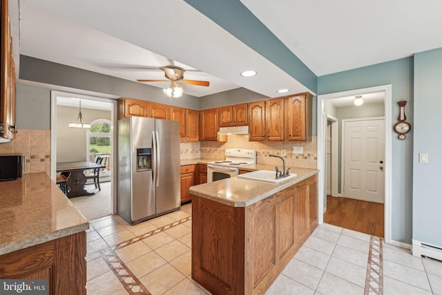 kitchen with stainless steel refrigerator with ice dispenser, electric stove, a sink, a peninsula, and under cabinet range hood
