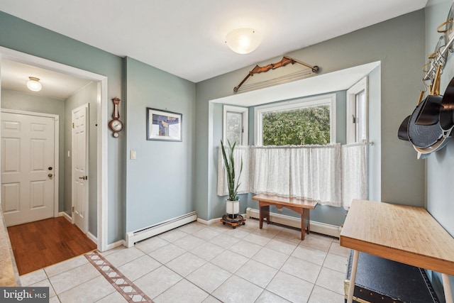 entrance foyer with baseboard heating, light tile patterned floors, and baseboards