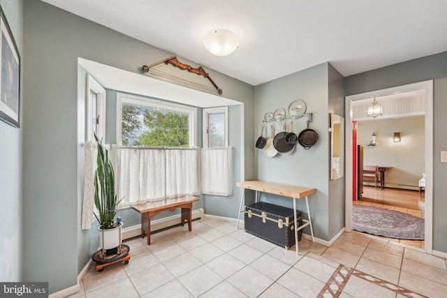 foyer entrance featuring light tile patterned floors, baseboards, and a baseboard radiator