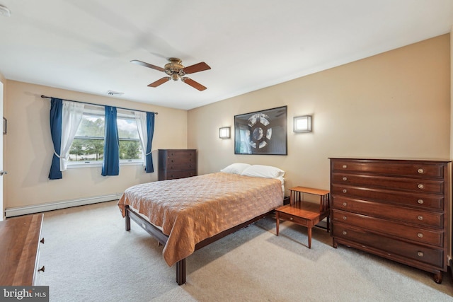 carpeted bedroom featuring a baseboard heating unit and ceiling fan