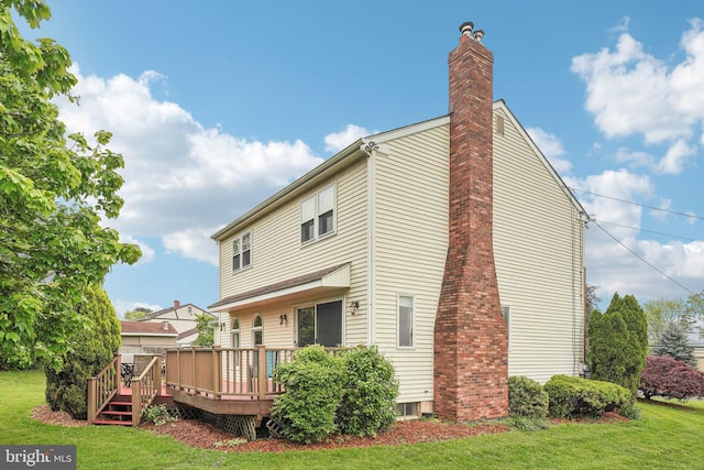 back of property with a lawn, a chimney, and a wooden deck