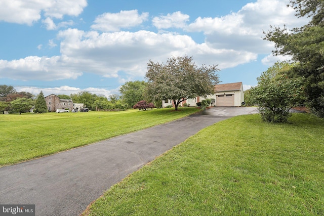 view of front of home with asphalt driveway, a garage, and a front lawn