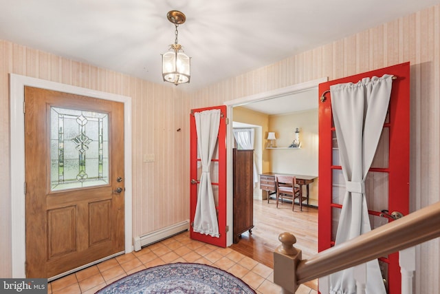 entryway with wallpapered walls, a baseboard radiator, light tile patterned floors, a chandelier, and baseboards