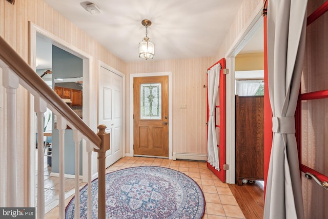 foyer with wallpapered walls, light tile patterned floors, baseboard heating, stairway, and baseboards