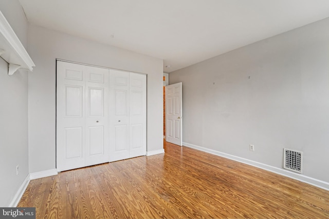 109 N Collington Ave, Baltimore, MD 21231 - unfurnished bedroom with wood finished floors and a closet